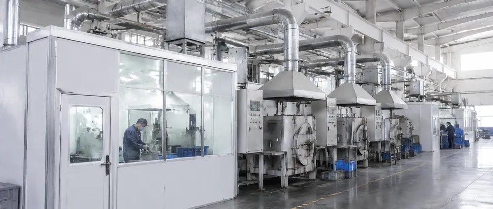 CLSEG factory floor showing enclosed powder rooms and fume extraction systems on sintering furnaces