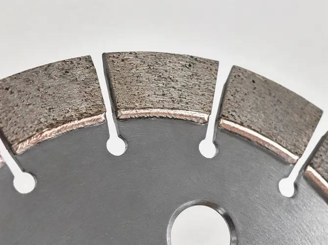 Close-up of granite diamond cutting disc segment showing hot-pressed sintered diamond grit in iron-cobalt bond matrix