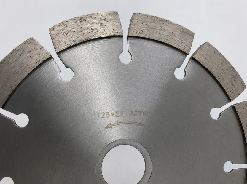 Close-up of wall chaser blade segment geometry showing wider gullets and 8-segment layout on a 125mm disc