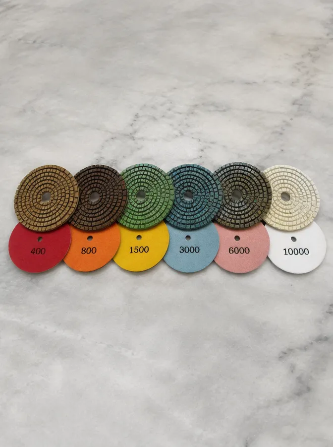 Resin-bonded polishing pads showing progressive grit sequence from 400 to 10000 for stone finishing