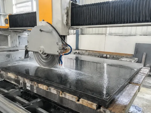 Bridge saw cutting hard granite countertop slab in fabrication shop