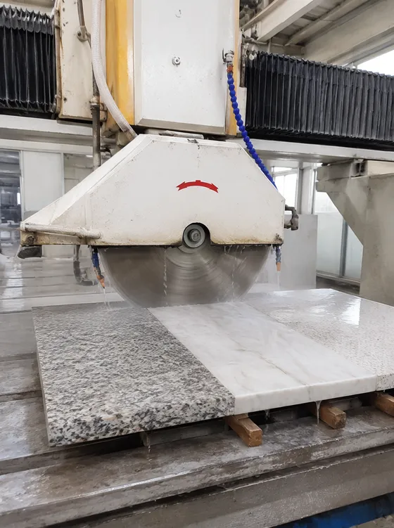 Bridge saw cutting through mixed stone materials — granite, marble, and engineered quartz slabs