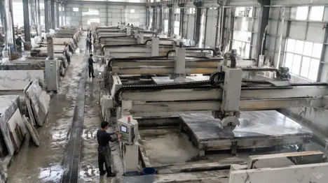 Large stone processing center with multiple bridge saws operating simultaneously