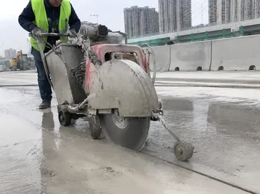 Road saw cutting concrete during infrastructure construction project