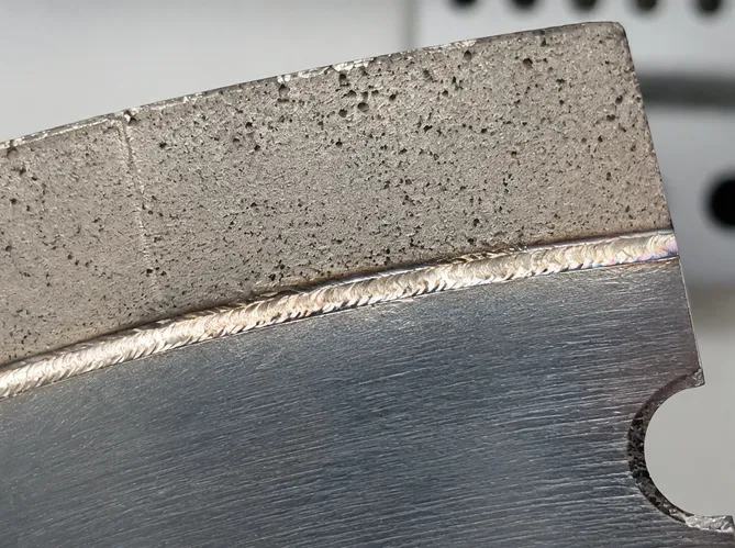 Close-up of laser welded joint between diamond segment and steel core showing metallurgical fusion