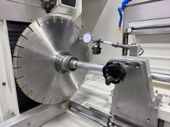 CNC tensioning machine with dial indicator measuring marble blade runout