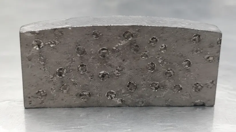 Glazed diamond saw blade segment showing dull diamonds trapped in uneroded bond matrix after cutting quartzite