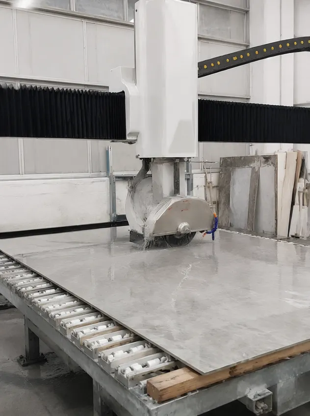 Bridge saw cutting a large-format porcelain slab panel in a fabrication workshop
