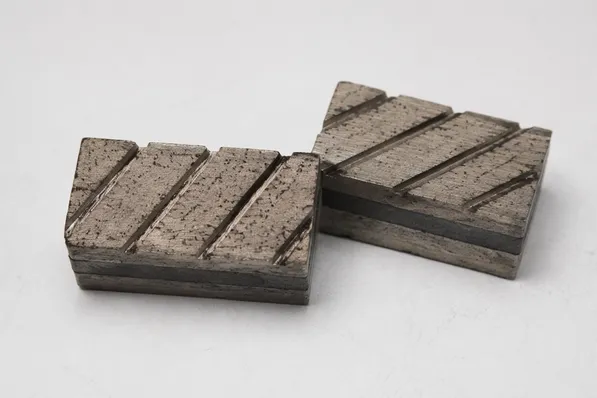 Turbo-slot diamond segment with angled slots for debris clearance